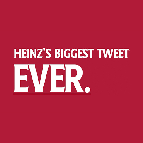 Opened red Heinz mini fridge containing ketchup bottles and tomatoes against a red background.