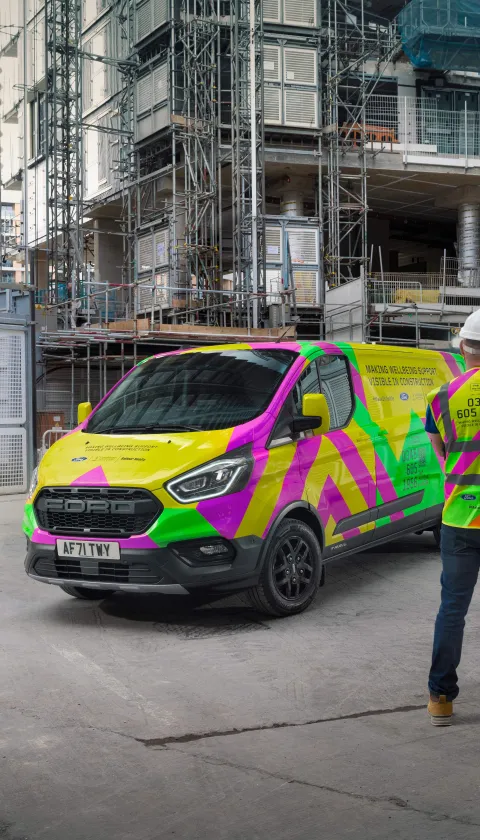 Two men in high vis next to van. 