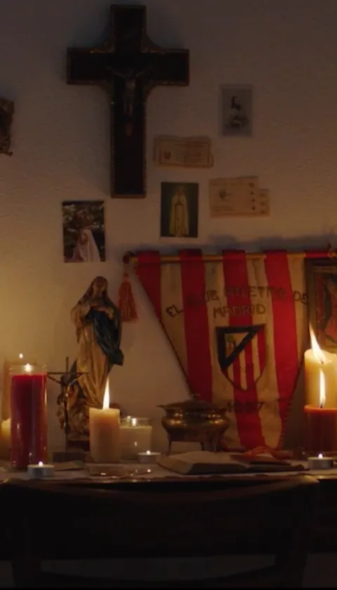 Religious shrine with holy items and lit candles in a dark setting.
