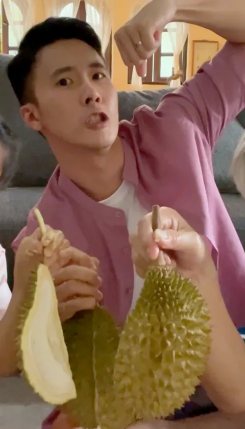 A family with a dad, son and daughter smiling and holding fruit.