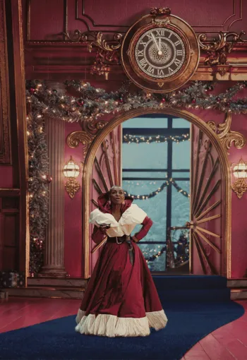 Christmas themed background with a lady dressed as Santa in the middle of the shot.